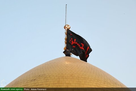 بالصور/ رفع الراية السوداء على قبة السيدة فاطمة المعصومة (ع) استعداداً لموسم عاشوراء